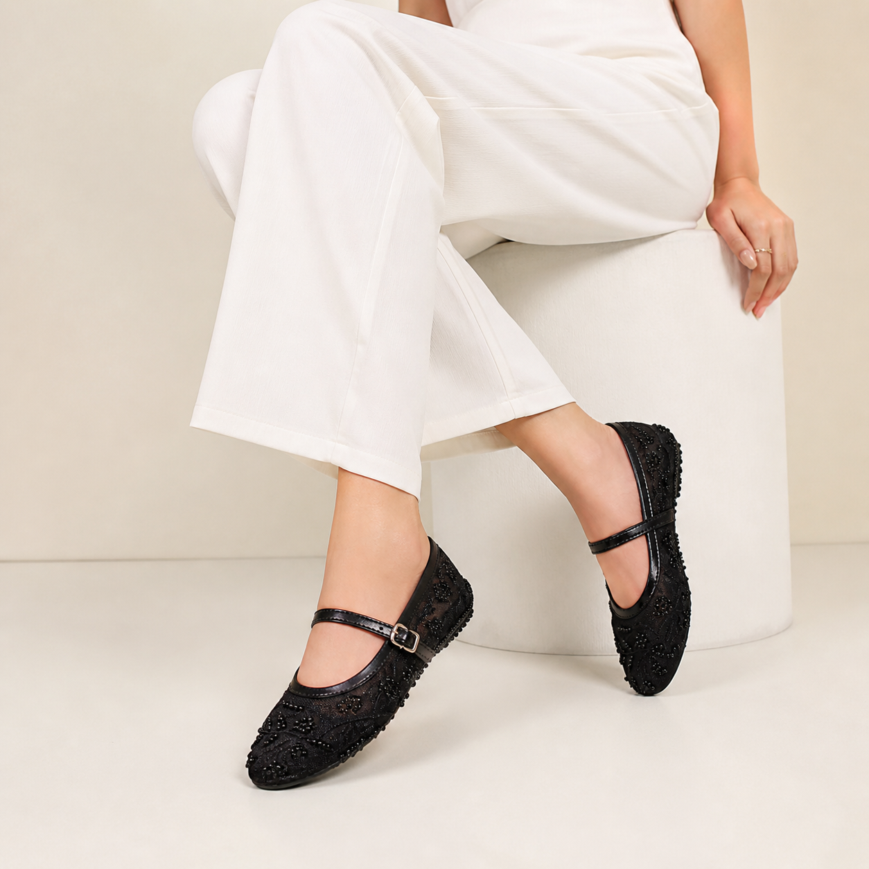 Black embroidered mule shoes by Finsha Shoes, featuring detailed embroidery and a sleek, slip-on design.