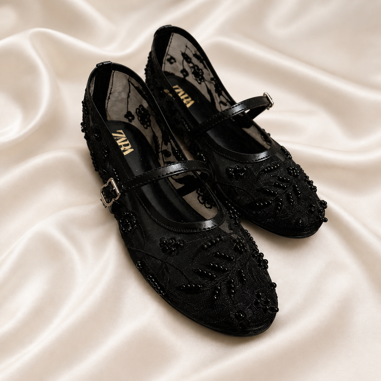 Black embroidered mules by Finsha Shoes featuring intricate embroidery and a stylish slip-on design.