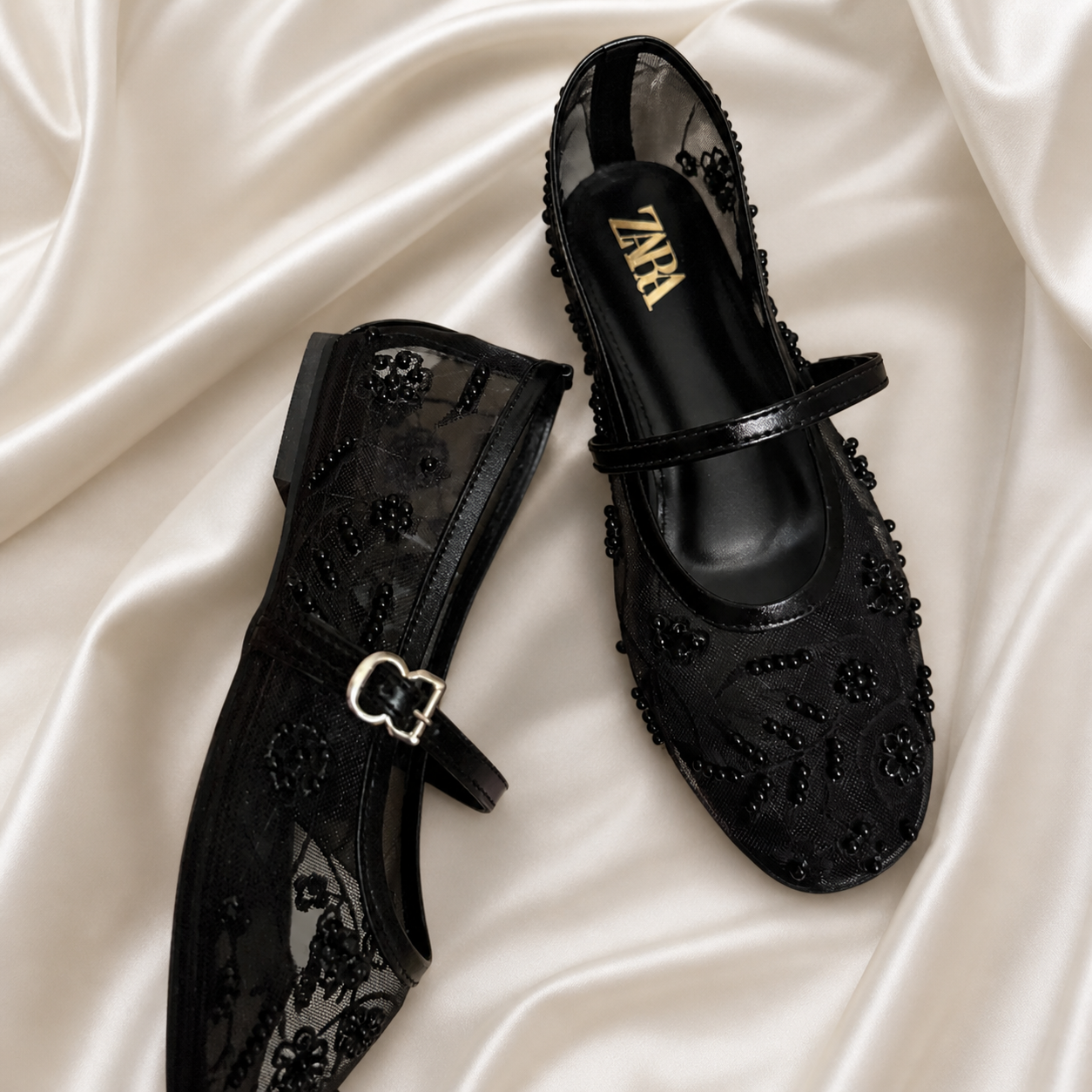 Black embroidered mules by Finsha Shoes featuring intricate embroidery and a stylish slip-on design.