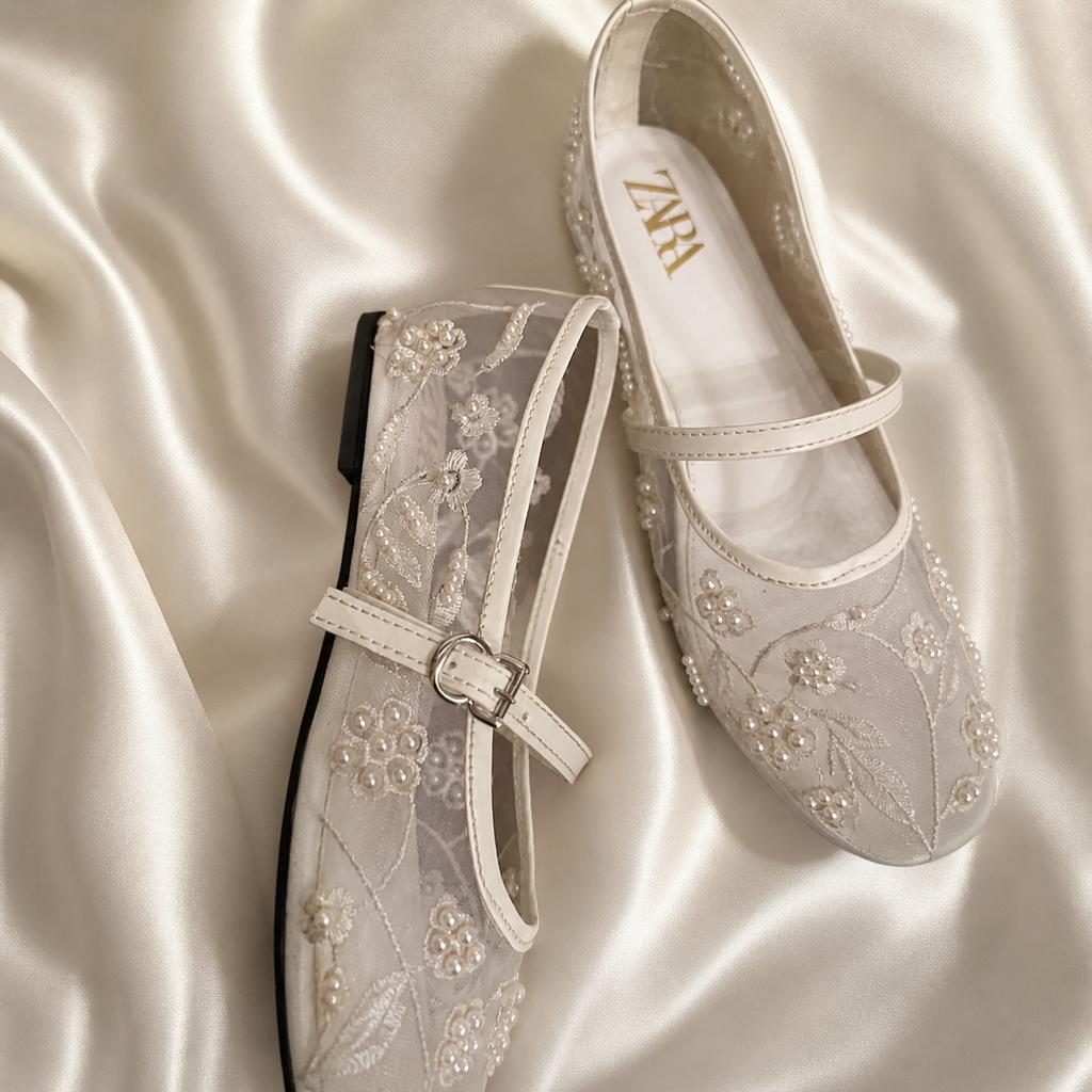 White embroidered Finsha Shoes black mules with intricate floral embroidery and pointed toe design.